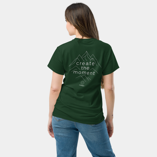 Back view of forest green T-shirt with mountain linework and “create the moment” text.