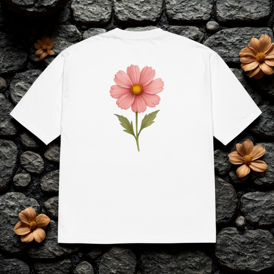Back view of white tee with large pink cosmos flower print, clean studio backdrop.