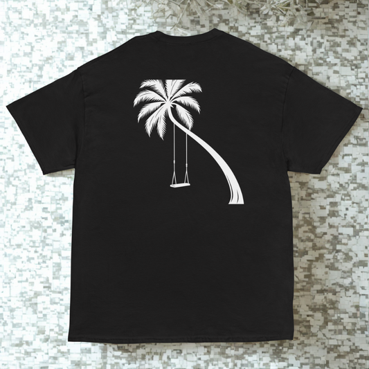 Back view of charcoal tee with leaning palm tree and hanging swing silhouette, tiled mosaic backdrop with soft plant shadows.