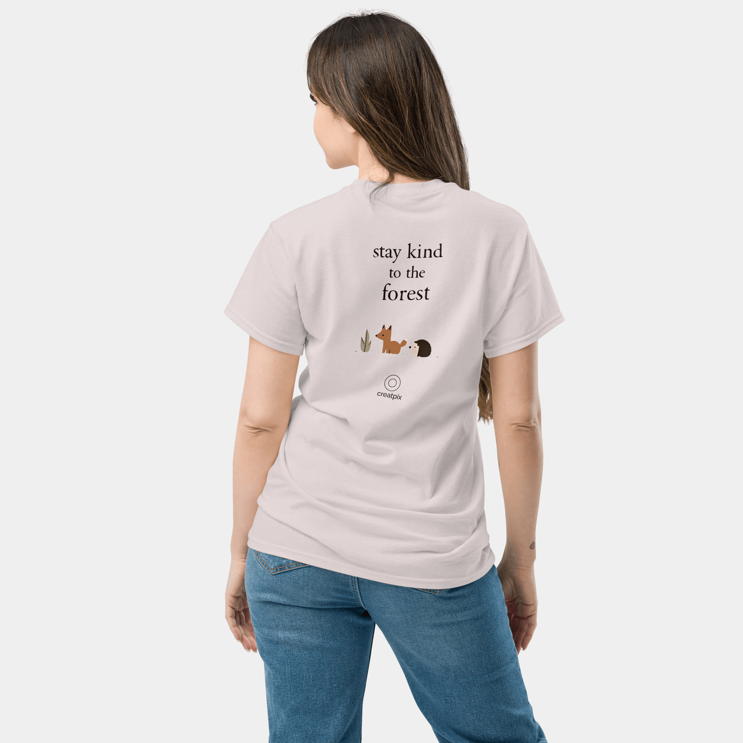 Back view of a white t-shirt with “stay kind to the forest” text above small cute woodland icons and a subtle Creatpix mark.