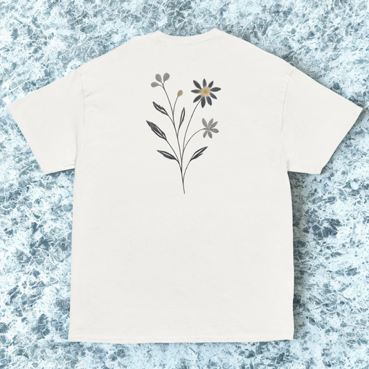Back view of white tee with delicate single wildflower stem centered high, cool marble backdrop.