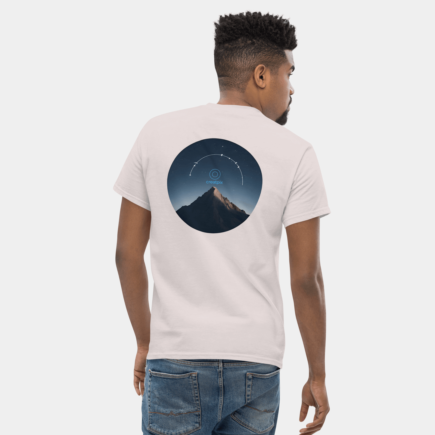 Back view of light Creatpix t-shirt with circular night mountain photo and small star arc.