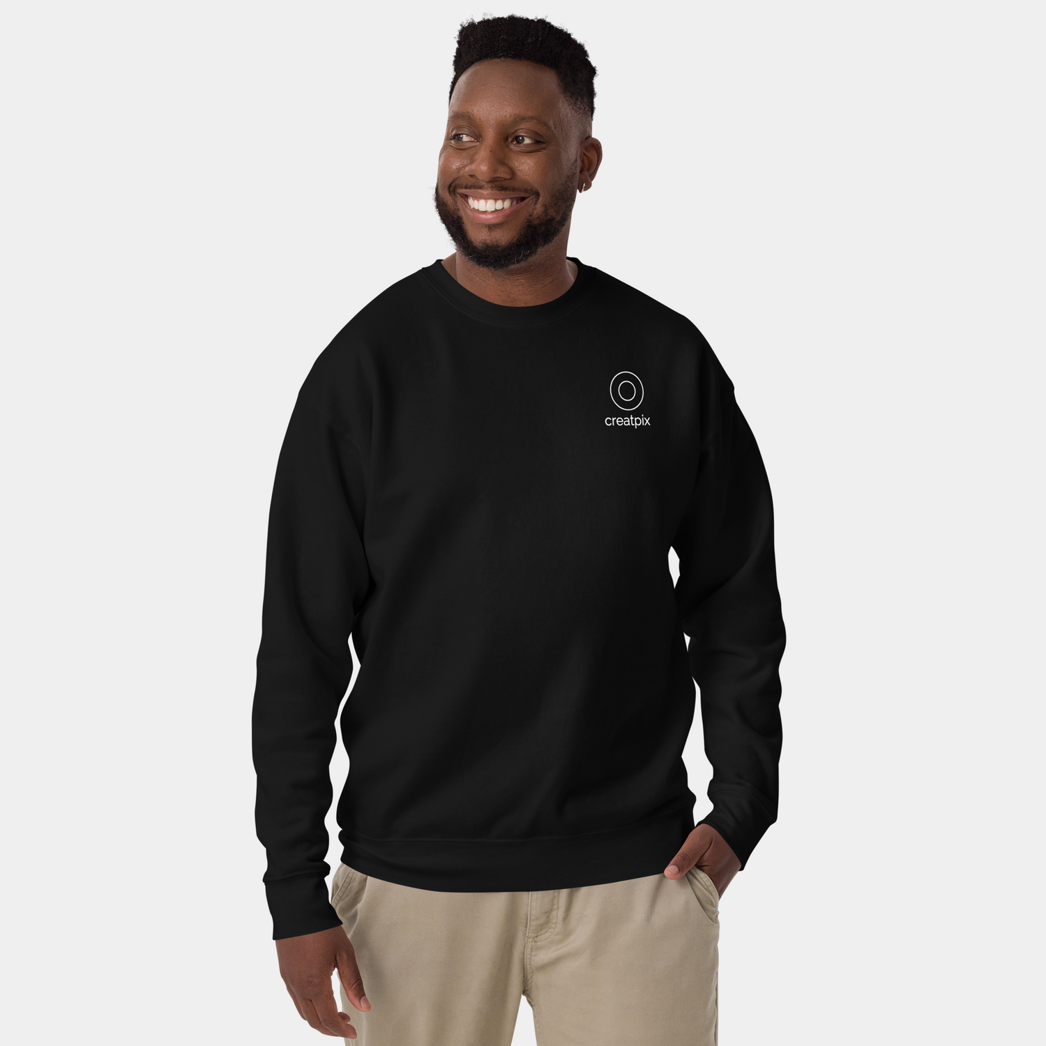 Man wearing a black classic crewneck sweatshirt with a small circular Creatpix logo on the left chest